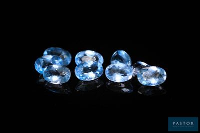 un ensemble de trois pierres précieuses de topaze bleue sur un fond noir