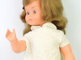 doll with blonde hair and blue eyes wearing a white dress