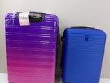 purple and blue suitcases sitting next to each other on a table