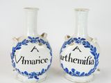 une paire de vases en céramique bleus et blancs portant les noms de deux personnes
