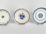 three blue and white plates with designs on them on a white surface