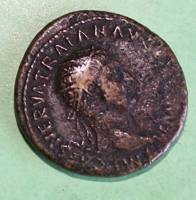 an old coin with a man ' s head on it on a green surface