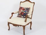 a white chair with a pillow on top of it in front of a white wall