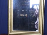 un miroir posé sur une commode qui comporte elle-même un miroir