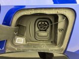a close up of a car ' s fuel tank with a blue car in the background