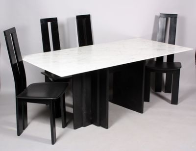 une table en marbre blanc avec des chaises noires et une chaise noire