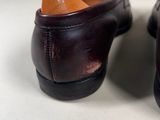 pair of men ' s brown leather shoes on a white surface