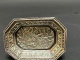an antique silver plate with a floral design on it