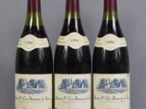 three bottles of wine are lined up on a table