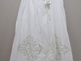 a white skirt hanging on a hanger against a wall