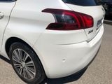the rear end of a white car parked in a parking lot