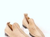 chaussures à enfiler pour hommes, en cuir fauve, sur une surface blanche