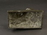 a silver box with a bird on it on a table