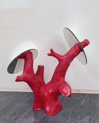 un arbre rouge surmonté d'un miroir