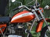 a red motorcycle parked in front of a palm tree
