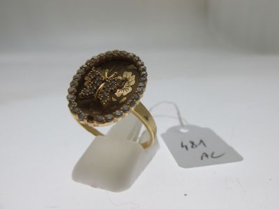 une image représentant une bague en or sertie d'une pierre marron