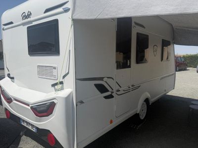 une photo d'un camping-car blanc garé sur un parking