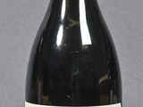 a bottle of wine sitting on a table next to a bottle of wine