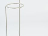 the white metal stand is holding a glass of water