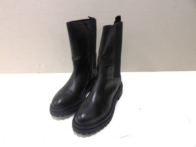 pair of black boots sitting on top of a white table