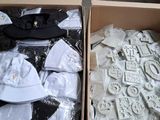 deux cartons contenant des casquettes et des t-shirts, qui se trouvent dans un carton