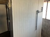 a white door in the middle of a room with a window