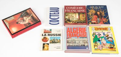 plusieurs livres posés sur une table blanche, sur laquelle se trouve une boîte rouge