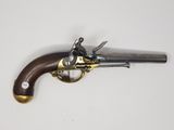 un vieux revolver avec une poignée en bois sur une surface blanche