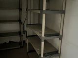 a room with shelves and a refrigerator in it