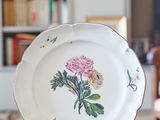 a plate with a flower on it sitting on a table
