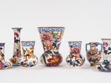 cinq vases ornés de motifs différents, posés sur un fond blanc