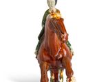 a figurine of a man riding a horse on a white background