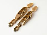 l'image d'une paire de boucles d'oreilles en or sur une surface blanche