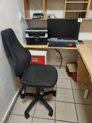 un bureau avec un ordinateur et une chaise dans un coin