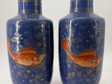 deux vases décorés de poissons, posés sur une table