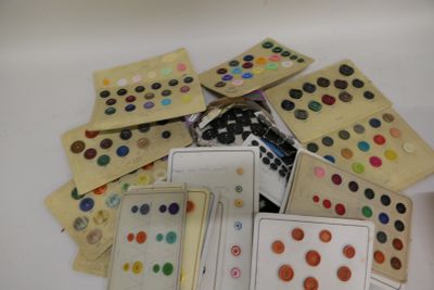 de nombreux boutons de différentes couleurs sur une surface blanche