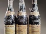 three bottles of wine wrapped in plastic sitting on top of a table