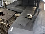un salon avec un canapé, une table basse et une télévision