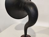a black antique phonom on a stand on a white table