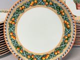 a stack of plates with oranges on them on a table