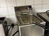 a deep fryer sitting on a counter in a kitchen