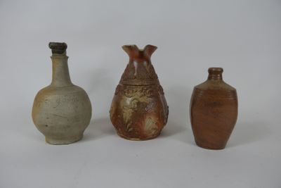 trois vases posés l'un à côté de l'autre sur une surface blanche