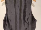 the back of a black vest hanging on a wooden hanger