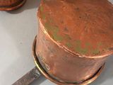 an old copper pot and a knife on a table