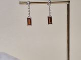 a close up of a pair of earrings on a stand