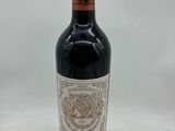 la bouteille de vin rouge est posée sur une surface blanche
