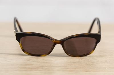 a close up of a pair of sunglasses on a wooden surface