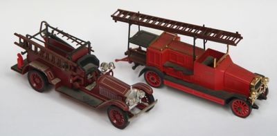 deux camions de pompiers miniatures posés l'un à côté de l'autre sur une surface blanche