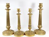 three brass candlesticks are sitting next to each other on a white surface