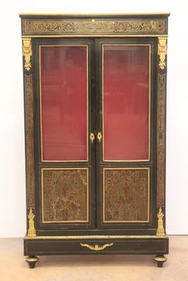 une armoire noire et dorée avec des portes rouges